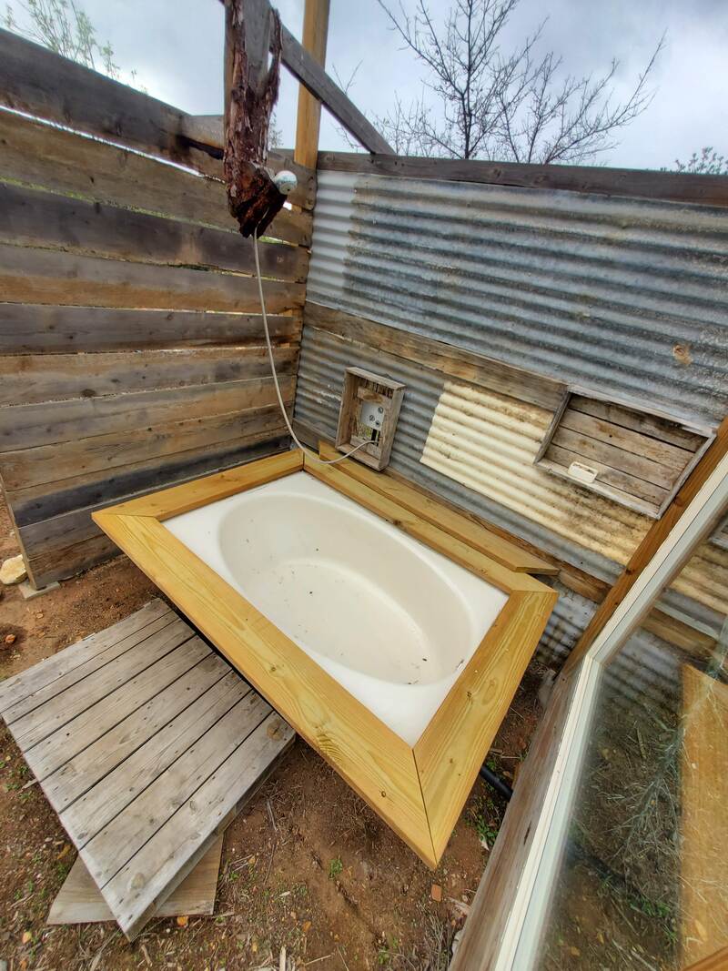 A bathtub and shower system built using reclaimed wood and corrugated metal in Ramona, San Diego County, California