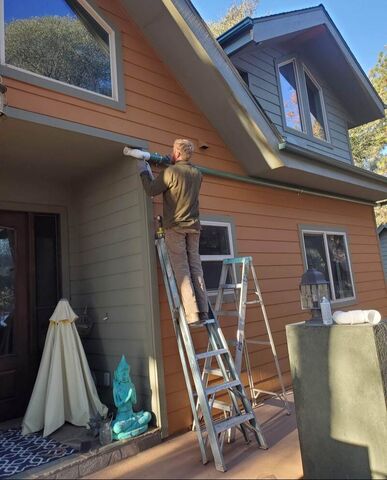 Chris Meador of Permasystems installing a rainwater harvesting system on a home in Julian with color matching pipe